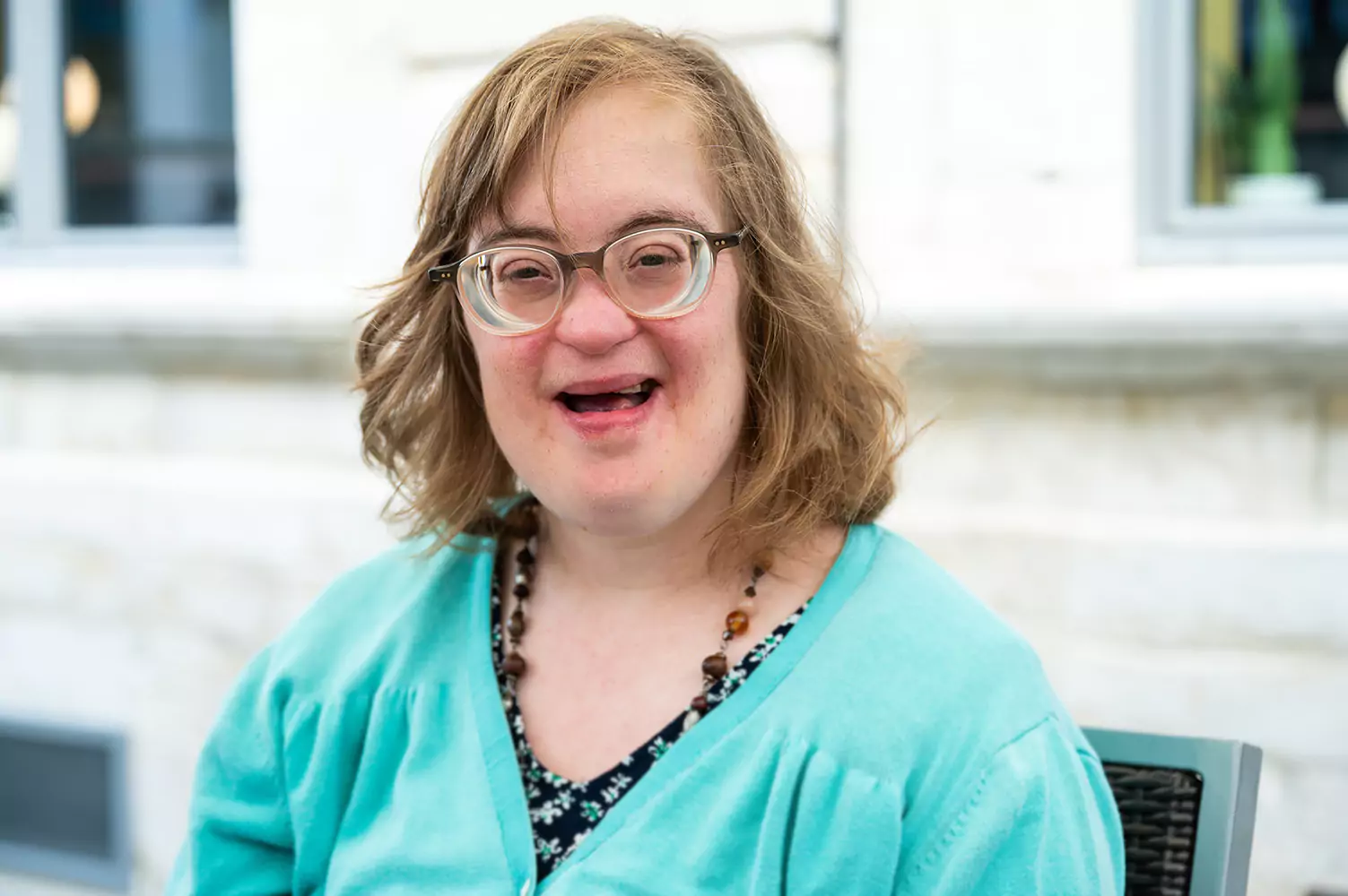 A woman with down syndrome smiling at the camera